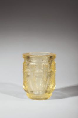 a close up of a yellow glass cup on a white surface