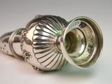 a silver vase that is sitting on a table