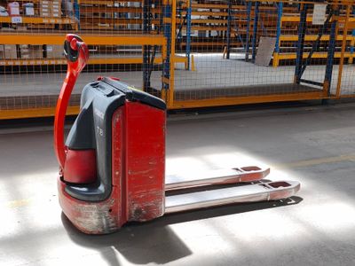 un chariot élévateur rouge garé dans un entrepôt