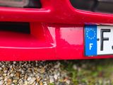 a red car with a blue and white license plate on it