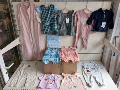 many baby clothes hanging on a clothes rack in a crib