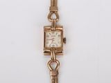 une image d'un gros plan d'une montre-bracelet sur une surface blanche