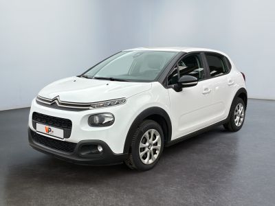 Une Citroën blanche est garée dans une pièce blanche