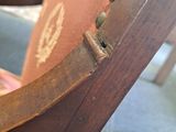 a close up of a wooden chair with a pink seat