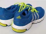 adidas running shoes with yellow laces on a white surface