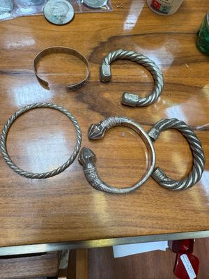 a wooden table with a bunch of bracelets on it