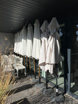 many umbrellas hanging on the outside of a building