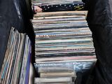 un sac noir rempli de disques vinyles posé par terre