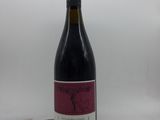 la bouteille de vin rouge est posée sur une surface blanche