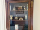une armoire en bois avec une porte vitrée, posée sur une cheminée