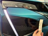 a person that is holding a ticket in front of a car