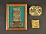 two gold medals and a framed picture of a cross on a green background