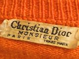 an orange sweater with a label on it that says christian dior monsieur