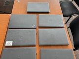 quatre ordinateurs portables posés sur une table dans une salle de réunion
