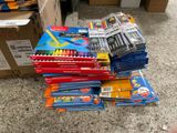 un tas de fournitures scolaires par terre, à côté d'un carton