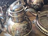 many silver teapots on a wooden table