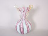 un vase en verre orné d'un motif à rayures roses et blanches