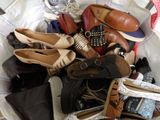 de nombreuses paires de chaussures dans un panier posé sur un lit