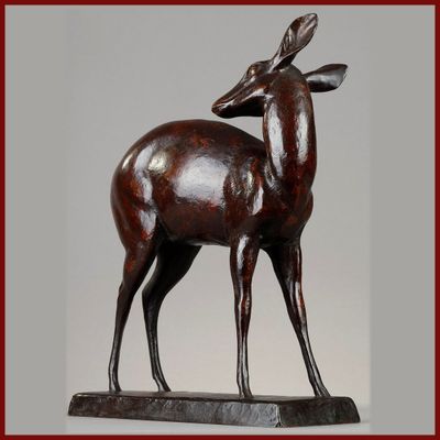 statue d'un cerf posée sur un socle en bois et encadrée d'un cadre rouge