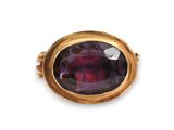 a close up of a ring with a purple stone in it