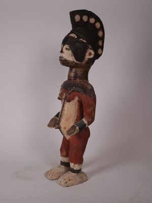 l'image d'une statue en bois représentant un homme avec un chapeau sur la tête