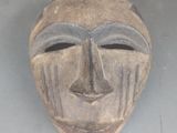 un masque en bois exposé sur une table