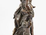 an antique bronze statue of a woman and child on a rock