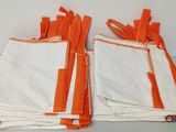 several orange and white cloths are stacked on top of each other