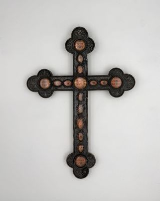 une croix de fer sur laquelle figurent les portraits d'un homme et d'une femme