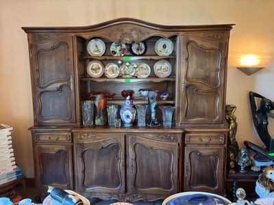 un vaisselier en bois sur lequel sont disposées de nombreuses assiettes