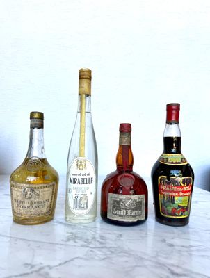 several bottles of liquor are lined up on a marble table