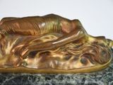 statue of a woman laying on a marble base with her head resting on her hands