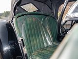 an old car with a green seat and a black seat cover