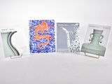 quatre livres exposés sur une table où se trouvent également des vases