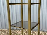 brass and glass etape with three shelves on top of it