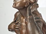 bronze statue of a woman holding a cell phone to her ear