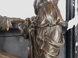 a bronze statue of a woman sitting on a bench