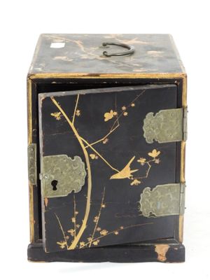 une boîte noire et dorée sur laquelle est représenté un oiseau