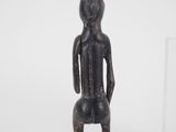 an image of a statue of a man sitting on a stool