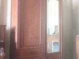 une armoire en bois surmontée d'un miroir, dans une pièce