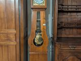 une horloge de parquet posée à côté d'un grand meuble en bois