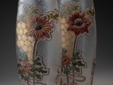 deux vases avec des fleurs peintes dessus, posés sur une table