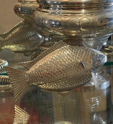 a glass table with a silver fish on top of it