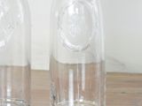 two empty glass bottles sitting on a wooden table
