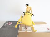 a figurine of a woman sitting on a surfboard