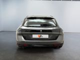 the rear end of a silver car in a white room