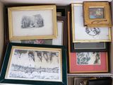 de nombreuses photos encadrées dans une boîte posée par terre