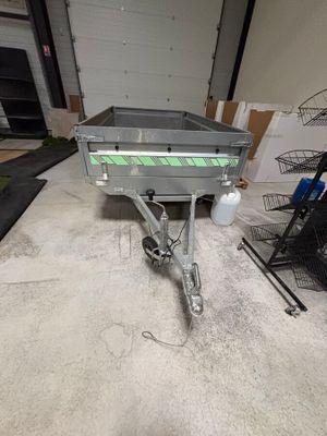 une photo d'une remorque dans un garage, avec plein d'objets éparpillés par terre