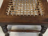 a wooden chair that has a woven seat on it