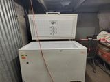 a refrigerator and freezer in a room with a lot of junk